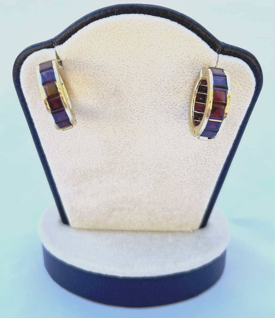 Angela Cummings 18K Gold Cuff Earrings with Red Garnet: Angela Cummings 18K Gold Cuff Earrings with Red Garnet Experience the elegance of these Angela Cummings earrings crafted from 18K yellow gold. This stunning pair features a unique cuff style adorned w