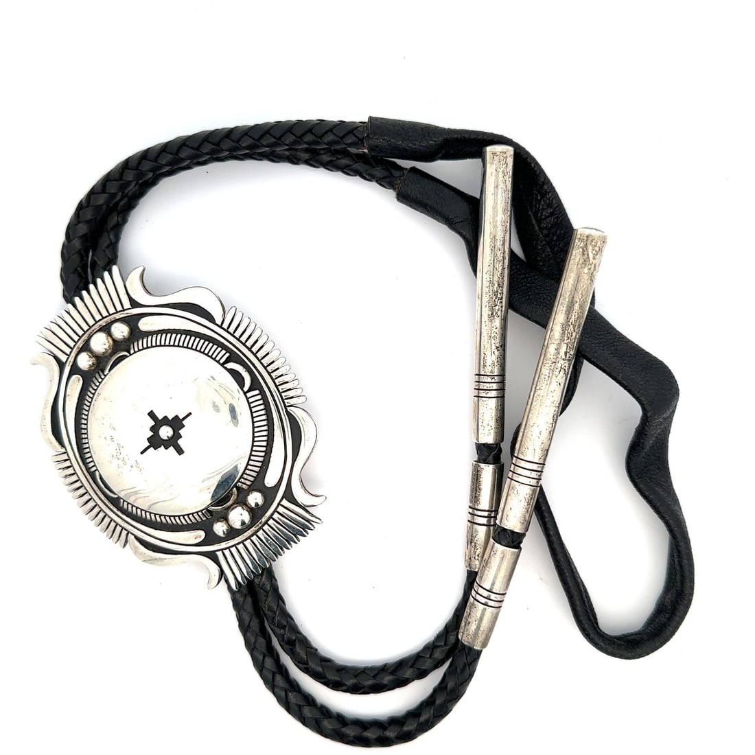 Sterling Silver Bolo Tie by Steven Begay with Black Leather Cord: Sterling Silver Bolo Tie by Steven Begay with Black Leather Cord This vintage bolo tie features a Southwestern-style centerpiece crafted from sterling silver, designed by Steven Begay. The tie is pair