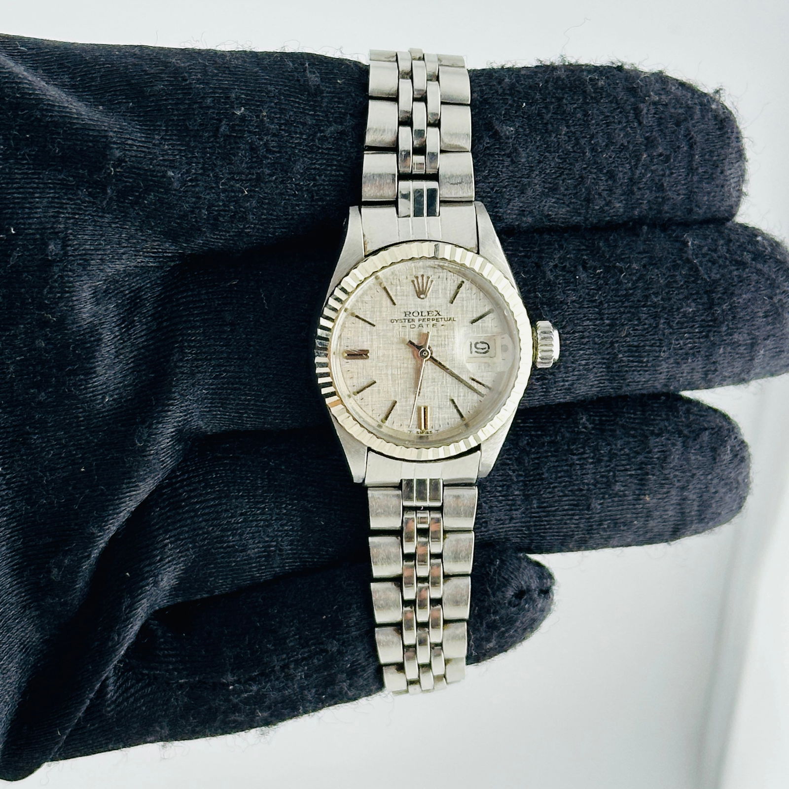 Ladies Rolex 6917/4 Oyster Perpetual Date Silver Linen Dial Folded Jubilee: Ladies Rolex 6917/4 Oyster Perpetual Date Silver Linen Dial Folded Jubilee This ladies' Rolex Oyster Perpetual Date features a silver linen dial and a fluted bezel. The watch is equipped with a folded