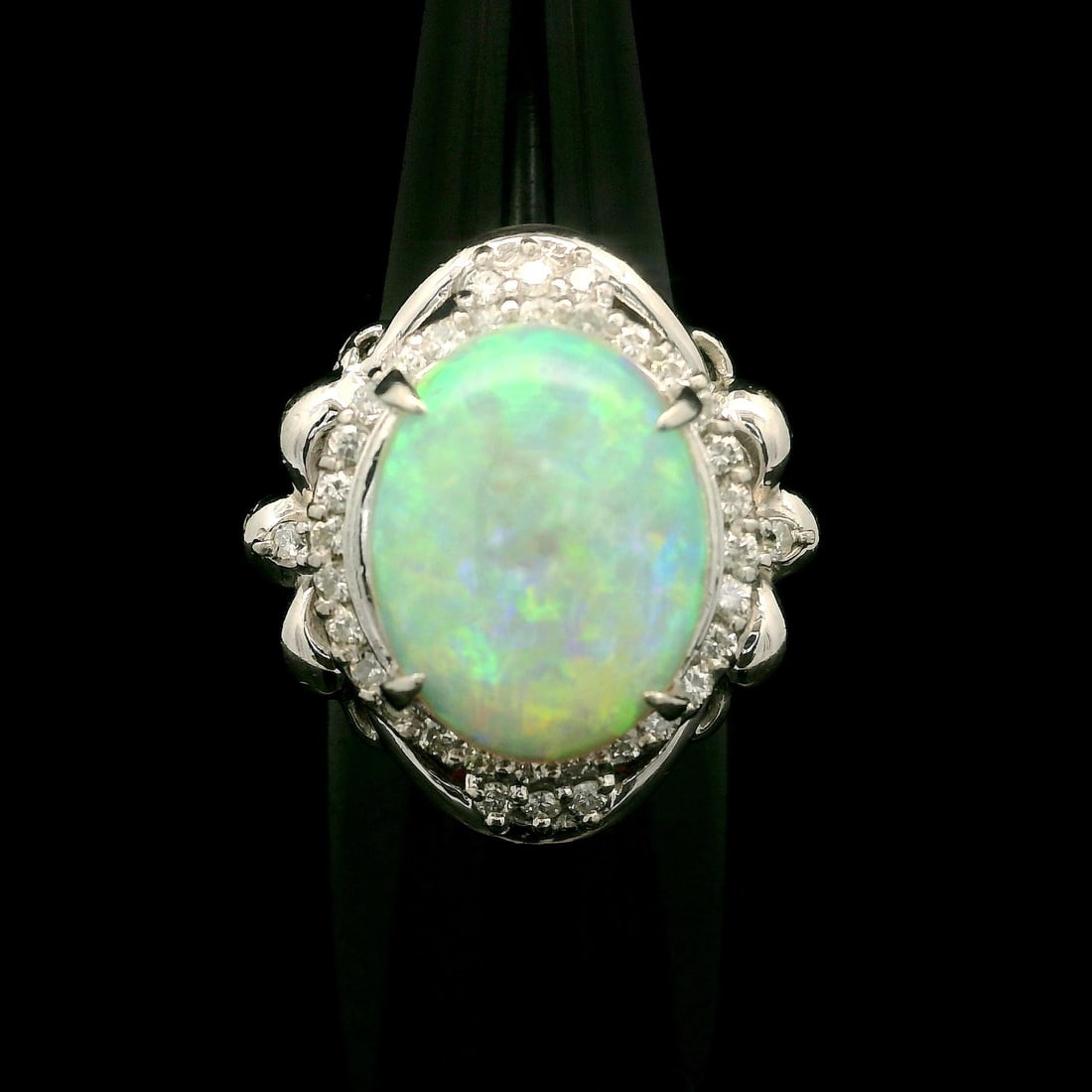 Vintage Platinum 4.88ct Oval Opal Diamond Halo Cocktail Ring: Vintage Platinum 4.88ct Oval Opal Diamond Halo Cocktail Ring This stunning vintage cocktail ring features a captivating 4.41ct natural opal, expertly cut in an oval cabochon shape and prong set to sho