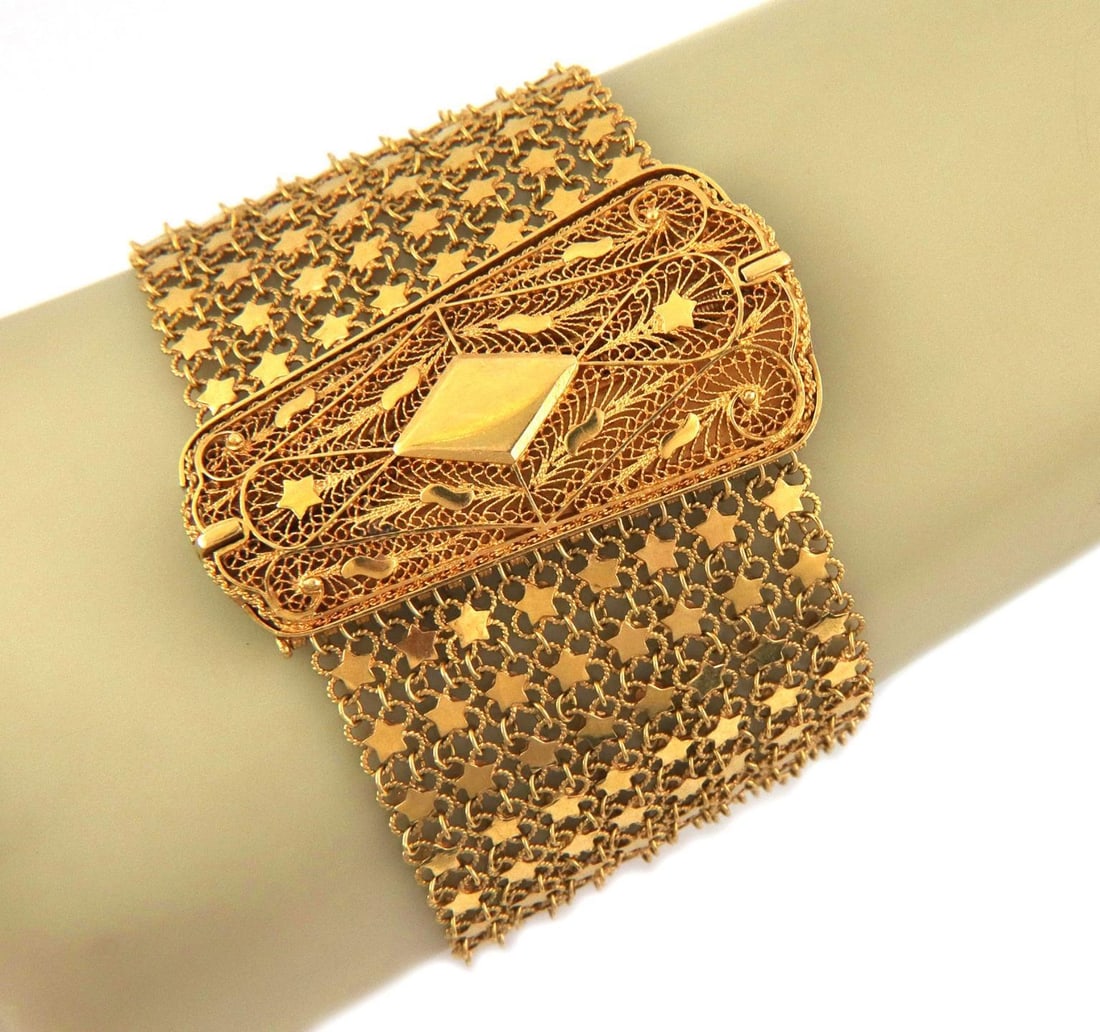 Vintage 22k Gold Bracelet Floral Filigree with Star Strands: Vintage 22k Gold Bracelet Floral Filigree with Star Strands This exquisite vintage bracelet is crafted from 22k yellow gold, showcasing a stunning floral filigree large clasp with a polished rhombus c