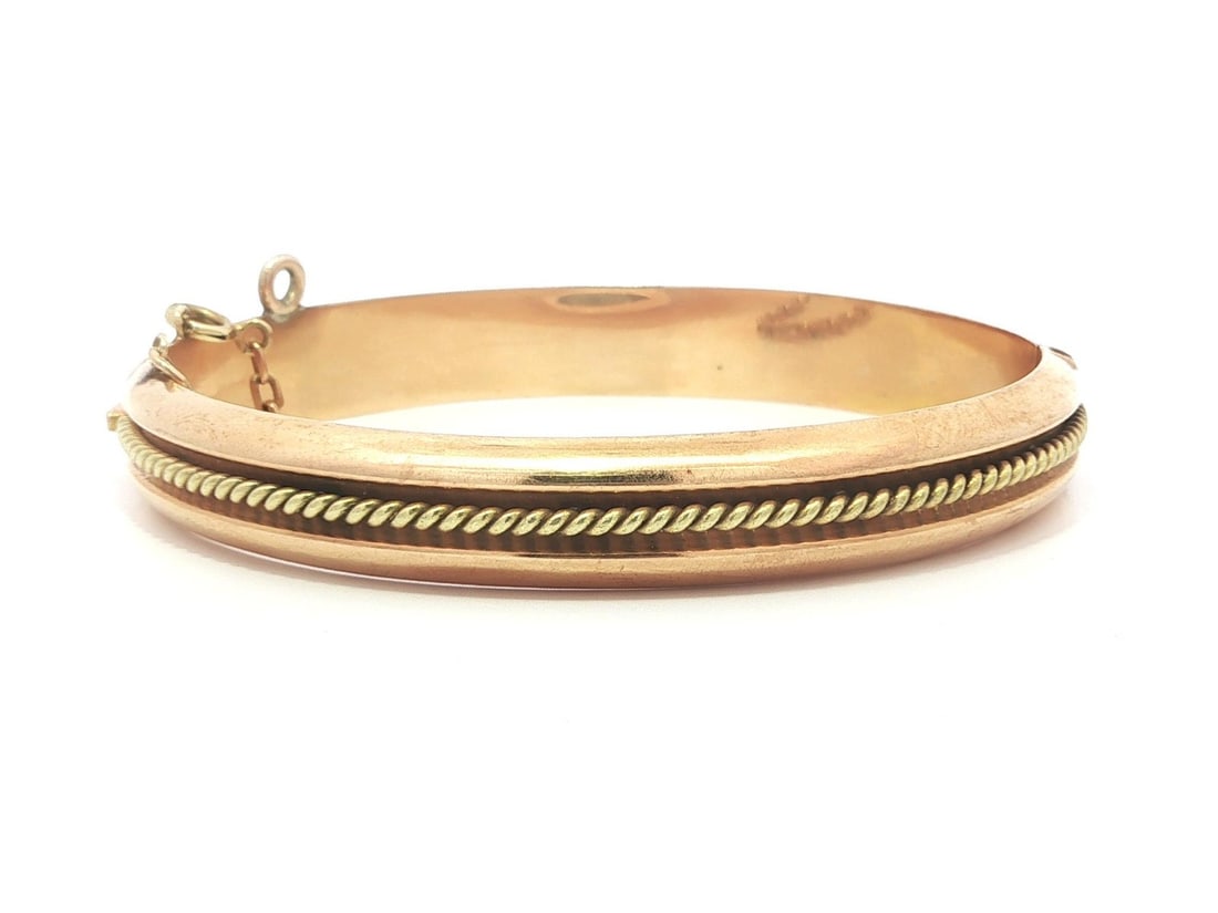 18k Rosy and Green Gold Twisted Wire Hinged Vintage Bangle Bracelet: 18k Rosy and Green Gold Twisted Wire Hinged Vintage Bangle Bracelet This vintage bangle bracelet is crafted from solid 18k rosy yellow gold, featuring a distinctive green gold twisted wire center and