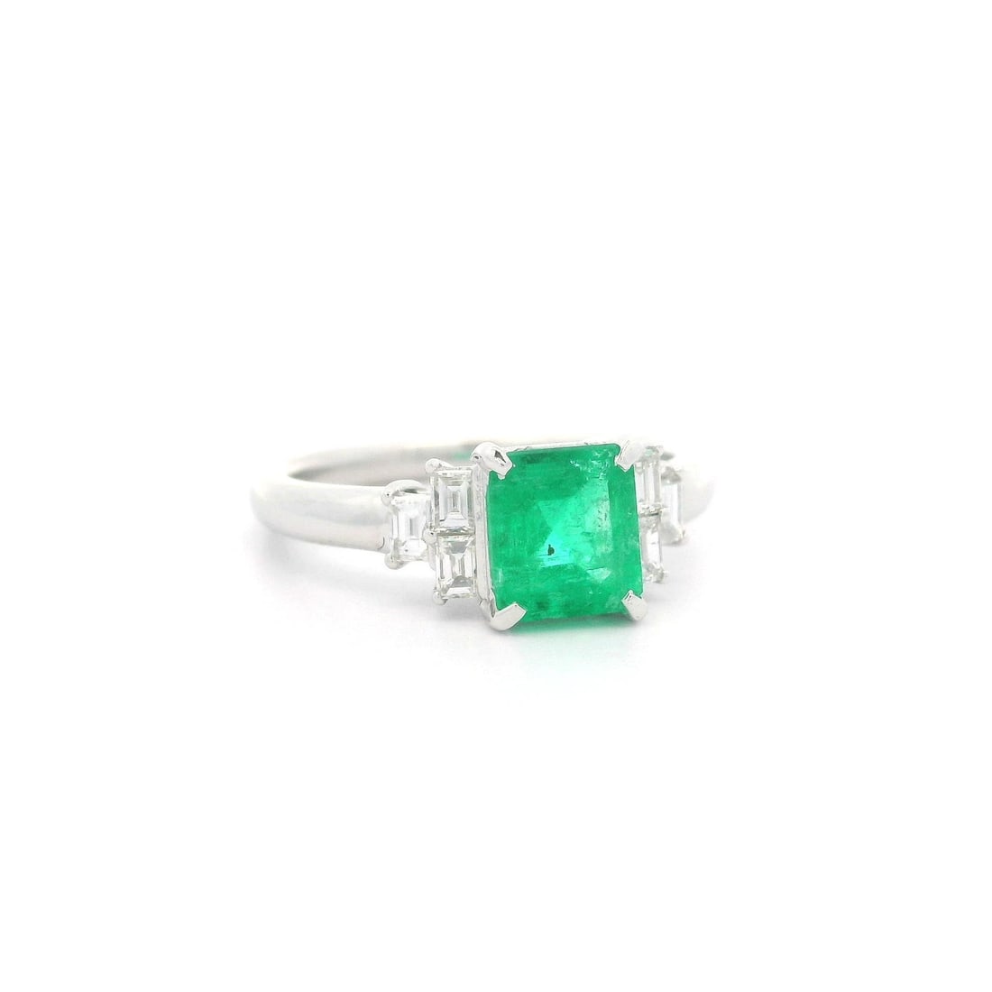Elegant Platinum 1.5ct Emerald and Baguette Diamond Step Ring: Elegant Platinum 1.5ct Emerald and Baguette Diamond Step Ring This exquisite ring features a stunning natural emerald at its center, showcasing a captivating emerald cut and a vibrant green hue. Flank