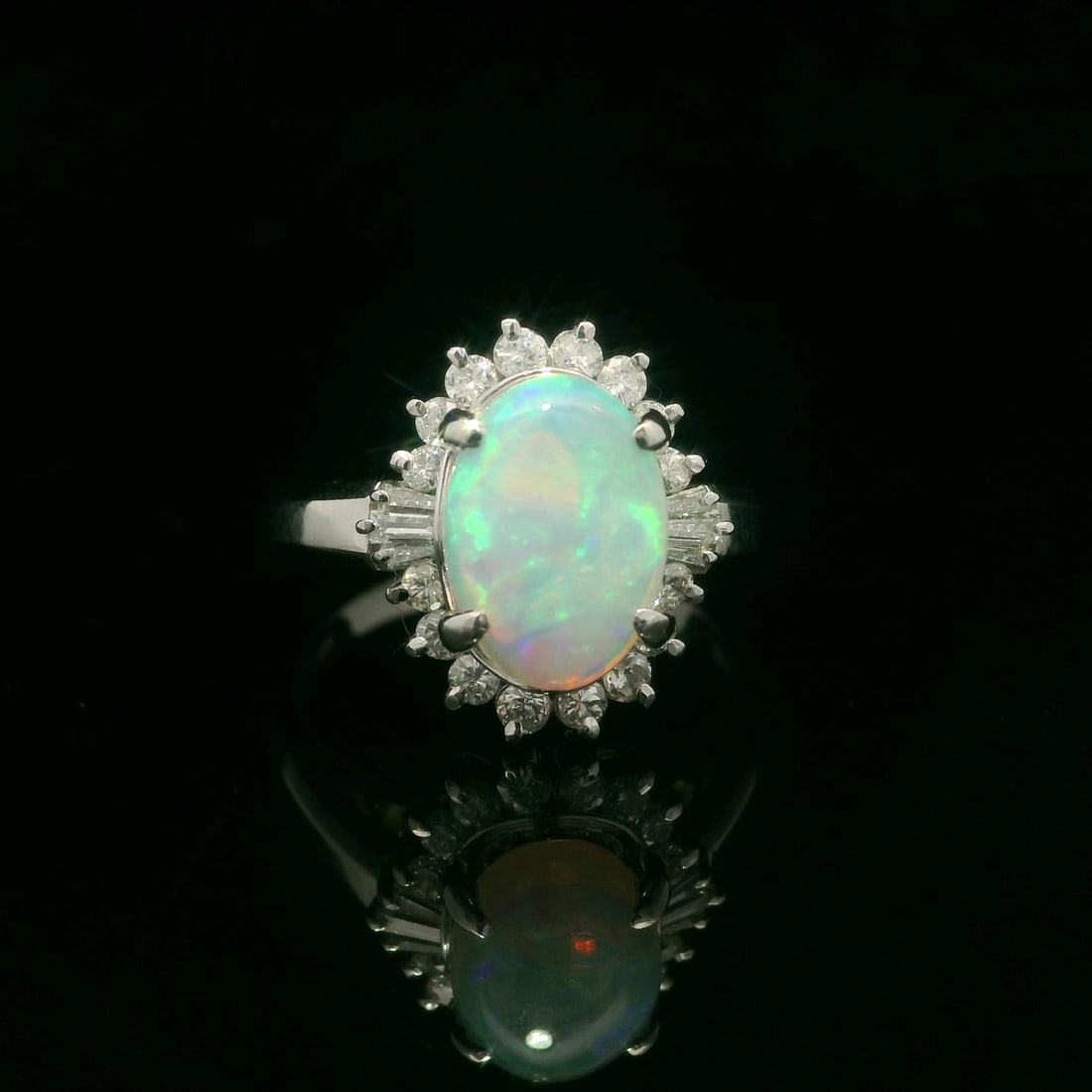 Platinum 1.66ctw Oval Opal Diamond Halo Cocktail Ring: Platinum 1.66ctw Oval Opal Diamond Halo Cocktail Ring This exquisite cocktail ring features a stunning natural opal in an oval cabochon cut, measuring 9.7x6.8mm and weighing 1.29ct. The opal showcases