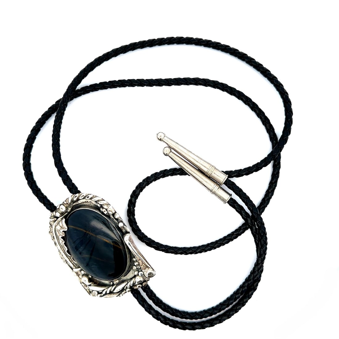 Sterling Silver Bolo Tie with Oval Hawk's Eye Cabochon and Black Leather Cord: Sterling Silver Bolo Tie with Oval Hawk's Eye Cabochon and Black Leather Cord This vintage bolo tie features a striking natural Hawk's Eye cabochon in an oval cut, bezel set in sterling silver. The de