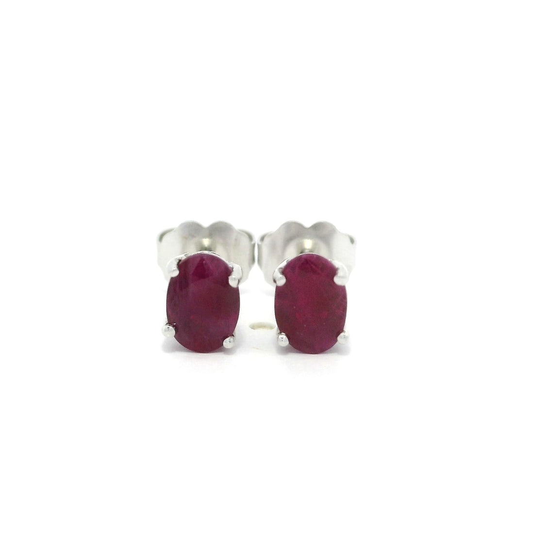 Natural Ruby Oval Cut Stud Earrings in 14k White Gold: Natural Ruby Oval Cut Stud Earrings in 14k White Gold Elevate your style with these exquisite 14k White Gold Ruby Stud Earrings. Featuring two natural, genuine oval cut rubies, these earrings showcase