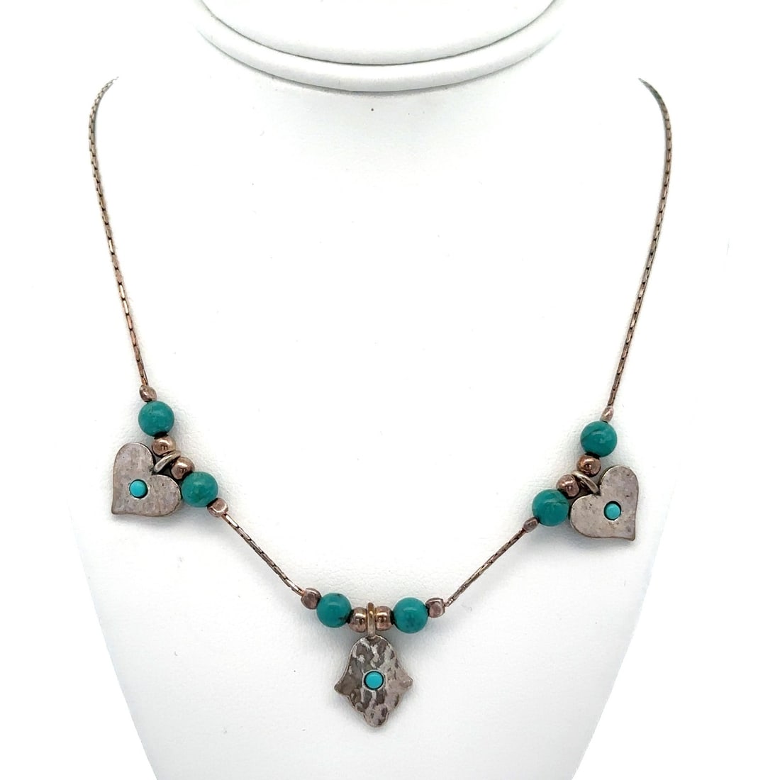 Handmade Sterling Silver Necklace with Turquoise Hearts and Hamsa Charms: Handmade Sterling Silver Necklace with Turquoise Hearts and Hamsa Charms This exquisite Handmade Sterling Silver Necklace features a delightful combination of turquoise hearts and a Hamsa hand charm.