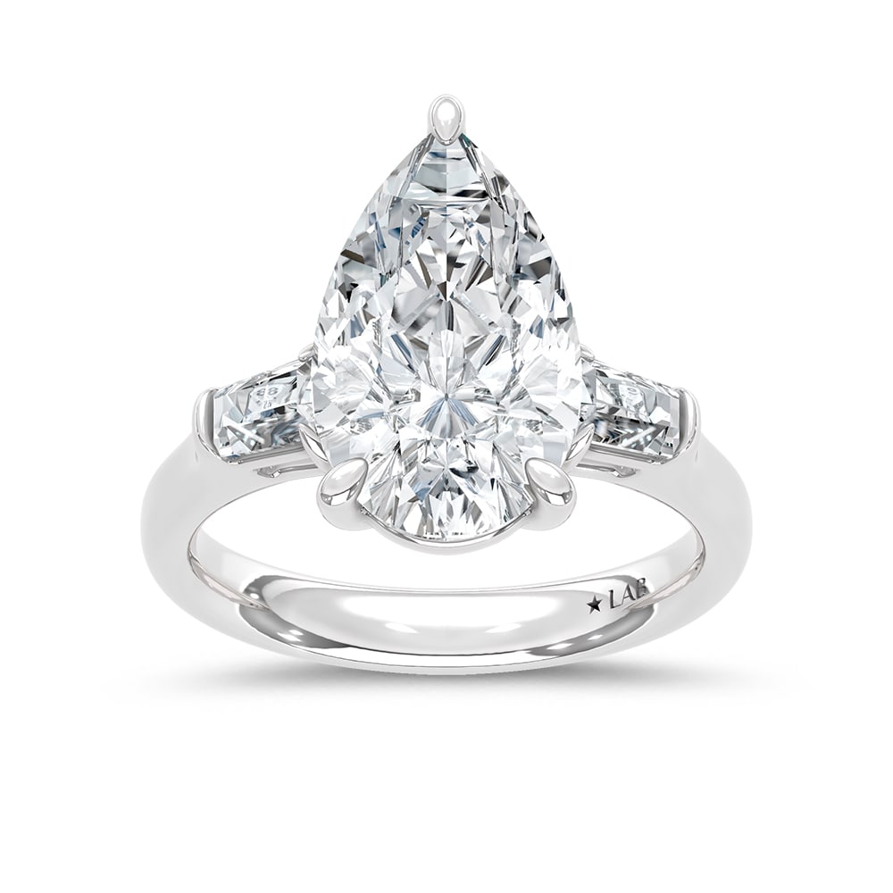 14K White Gold Lab Grown Diamond 5 1/3 Ct.Tw. Pear and Tapper Three Stone Engagement Ring: 14K White Gold Lab Grown Diamond 5 1/3 Ct.Tw. Pear and Tapper Three Stone Engagement Ring This stunning three-stone ring features a sparkling 5 CT Pear Center diamond with two shimmering side diamonds