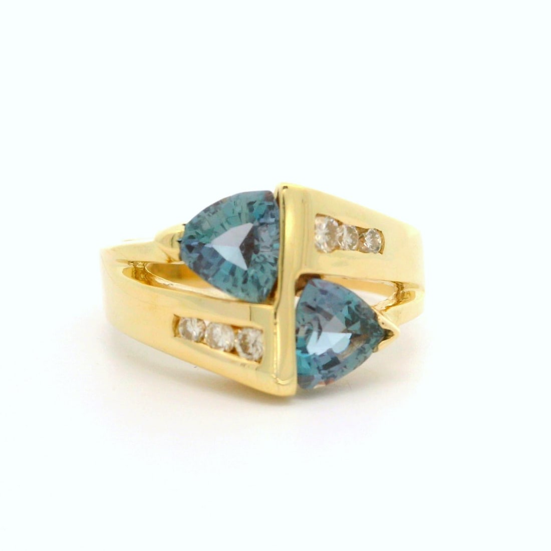 14k Yellow Gold Bypass Cocktail Ring with Synthetic Alexandrite and Diamonds: 14k Yellow Gold Bypass Cocktail Ring with Synthetic Alexandrite and Diamonds This stunning bypass cocktail ring features two trillion cut synthetic Alexandrite stones, showcasing a captivating bluish-