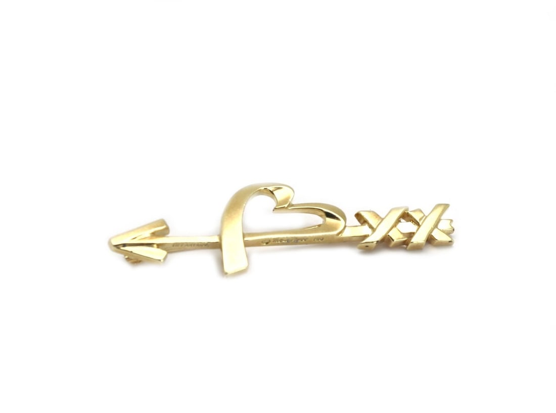 Tiffany & Co. Paloma Picasso 18k Gold Arrow Heart X Design Brooch: Tiffany & Co. Paloma Picasso 18k Gold Arrow Heart X Design Brooch This exquisite brooch from Tiffany & Co. features a unique design by renowned designer Paloma Picasso, showcasing an arrow integrated