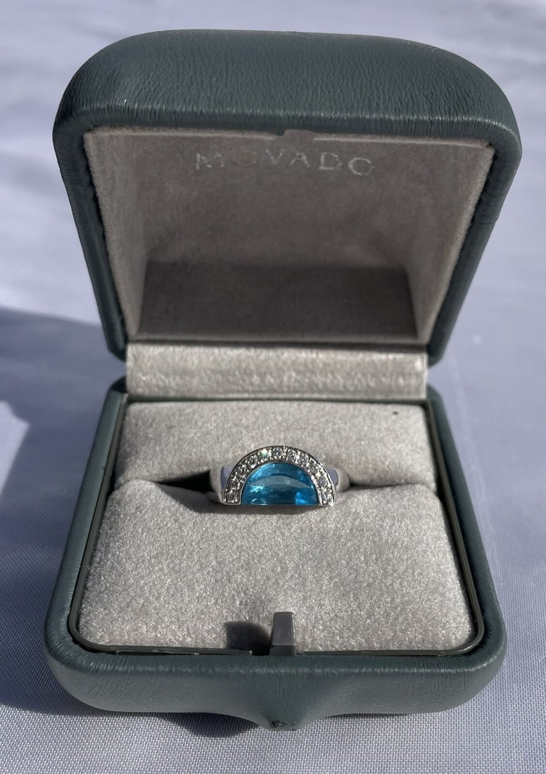 Movado 18K White Gold Diamond Topaz Ring with Box Size 7.25: Movado 18K White Gold Diamond Topaz Ring with Box Size 7.25 Discover the elegance of this Movado 18K White Gold Diamond Topaz Ring, expertly crafted with precision and artistry. This stunning piece