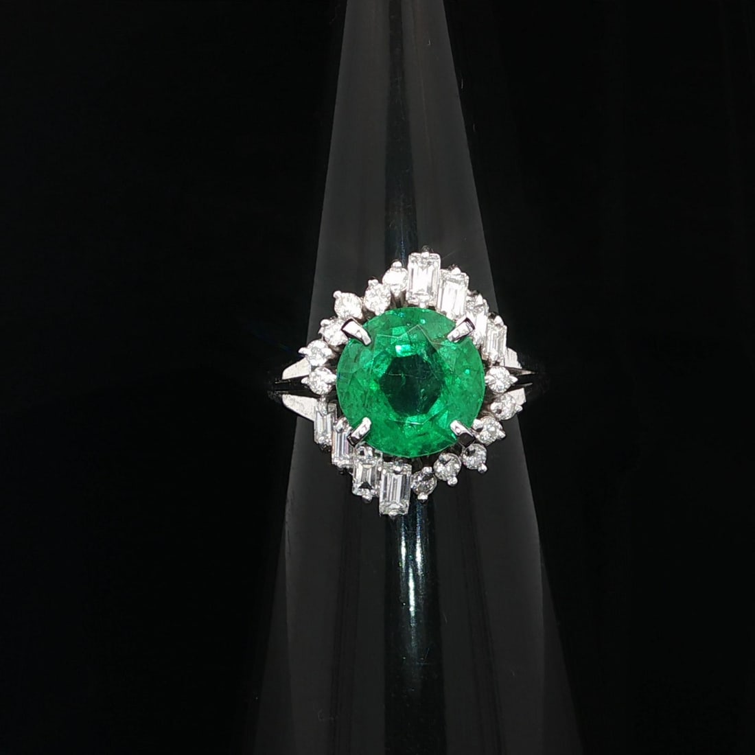 Vintage GIA Certified 3.25ct Emerald Diamond Ring in Platinum: Vintage GIA Certified 3.25ct Emerald Diamond Ring in Platinum This exquisite vintage ring showcases a stunning 3.25ctw vivid green round emerald, accented with sparkling diamonds. The centerpiece is a