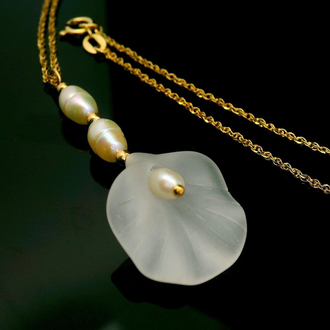 14k Gold Calla Lily Rock Crystal Pearl Necklace 20": 14k Gold Calla Lily Rock Crystal Pearl Necklace 20" This exquisite necklace features a beautifully carved calla lily flower crafted from 14k yellow gold, showcasing the elegance of nature. Adorning th