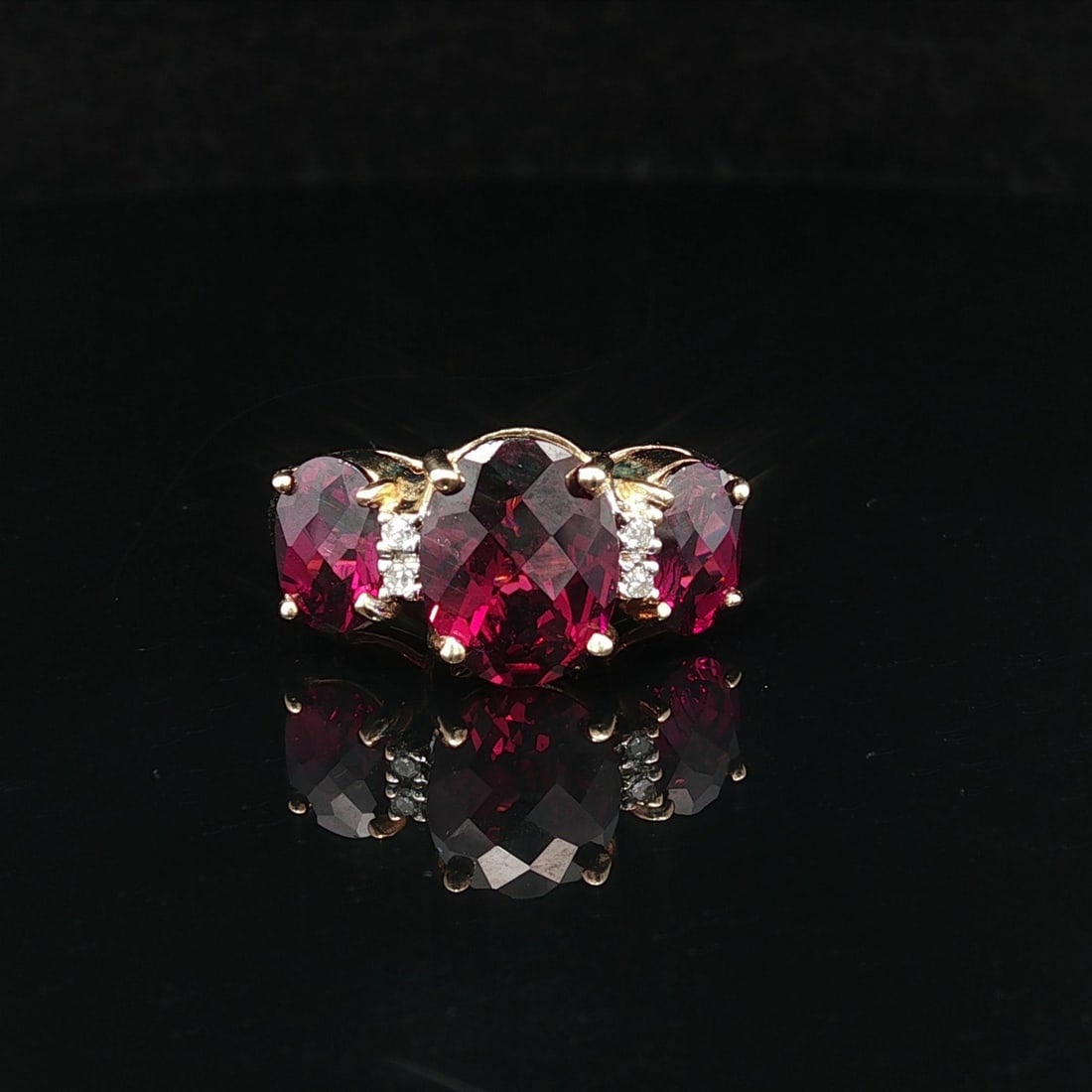 14k Yellow Gold Garnet Diamond 3 Stone Cocktail Ring: 14k Yellow Gold Garnet Diamond 3 Stone Cocktail Ring This exquisite cocktail ring features a stunning design with three natural genuine Rhodolite garnets and sparkling diamonds. The centerpiece is a c