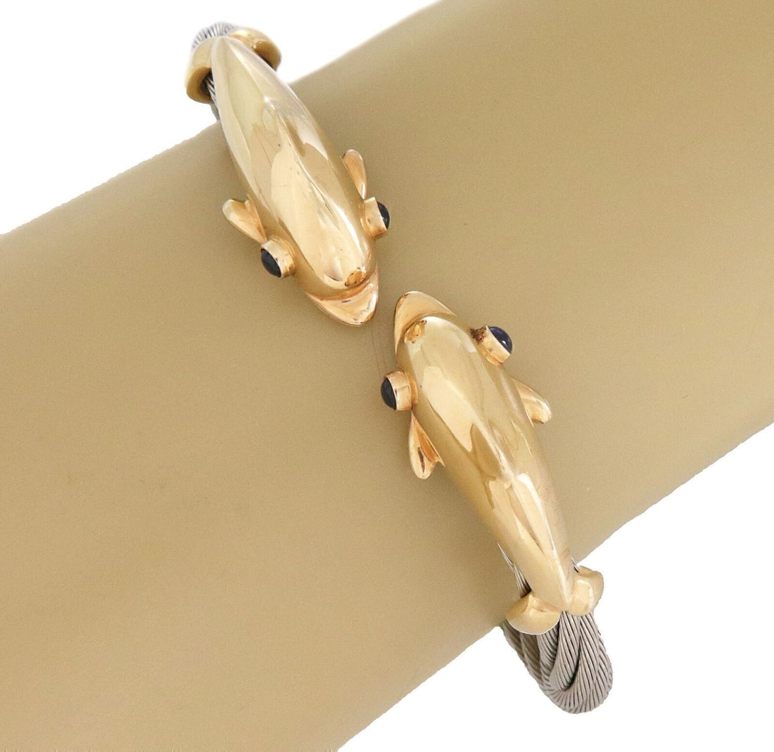 Double Dolphin Sapphire Bangle in 14k Gold and Steel by Steven Douglas: Double Dolphin Sapphire Bangle in 14k Gold and Steel by Steven Douglas This Steven Douglas cuff bangle bracelet features an elegant double dolphin motif crafted in 14k yellow gold and stainless steel.