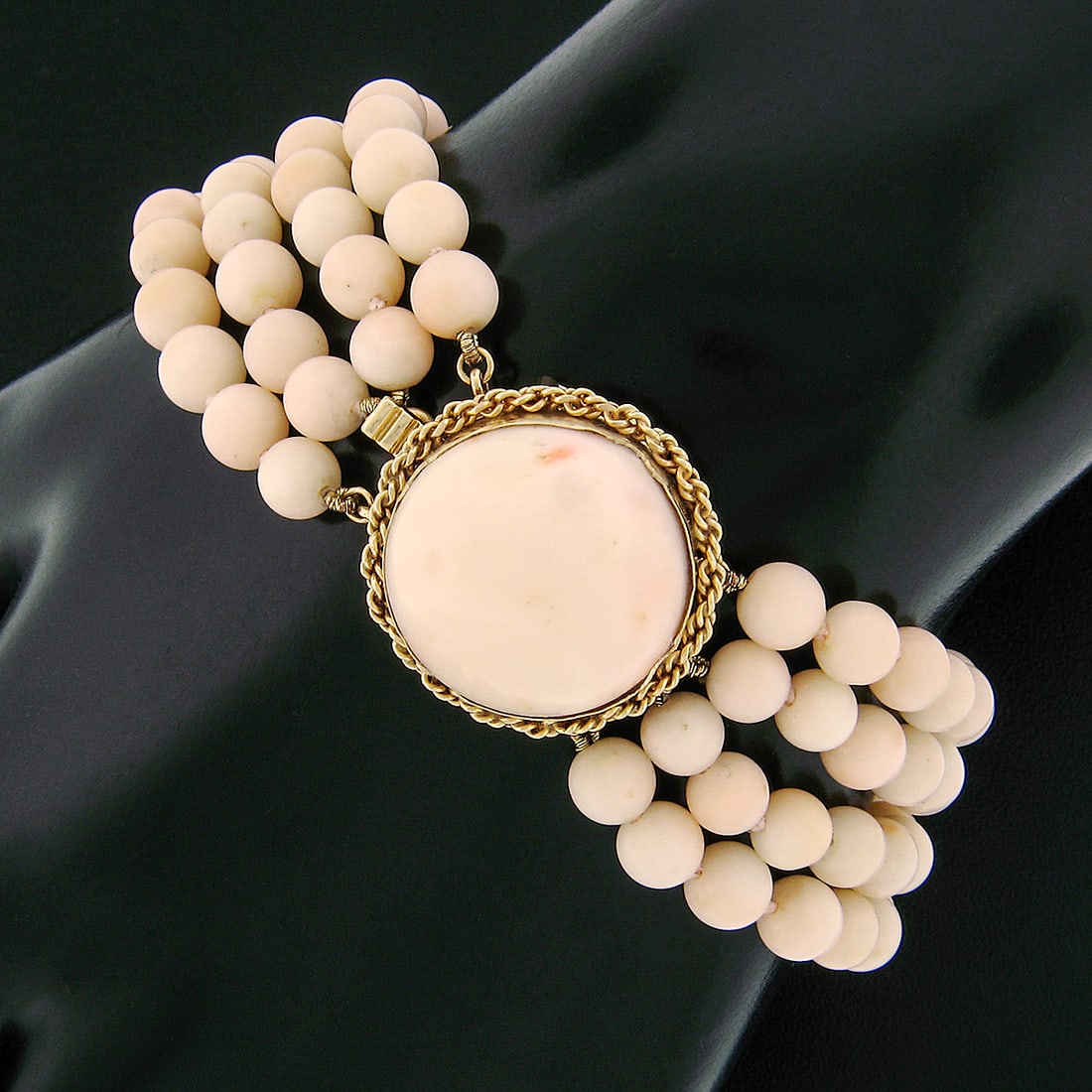 Vintage 14k Yellow Gold 4 Strand Angel Skin Coral Bracelet: Vintage 14k Yellow Gold 4 Strand Angel Skin Coral Bracelet This stunning vintage bracelet features a luxurious design crafted from solid 14k yellow gold and showcases a large 18mm round cabochon natur