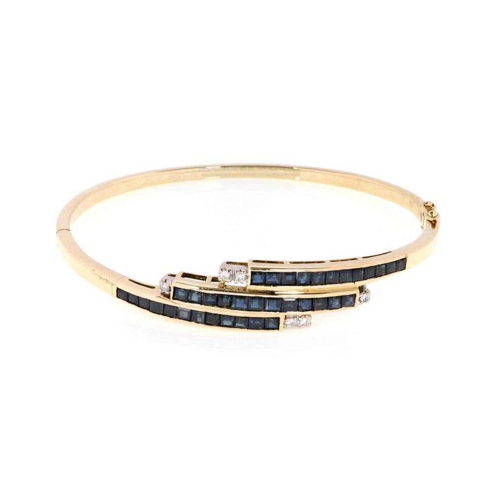 14k Yellow Gold Triple Row Sapphire Diamond Bangle Bracelet: 14k Yellow Gold Triple Row Sapphire Diamond Bangle Bracelet This exquisite bangle bracelet is crafted from 14k yellow gold and features a unique hinge design for easy wear. The front showcases a stunn