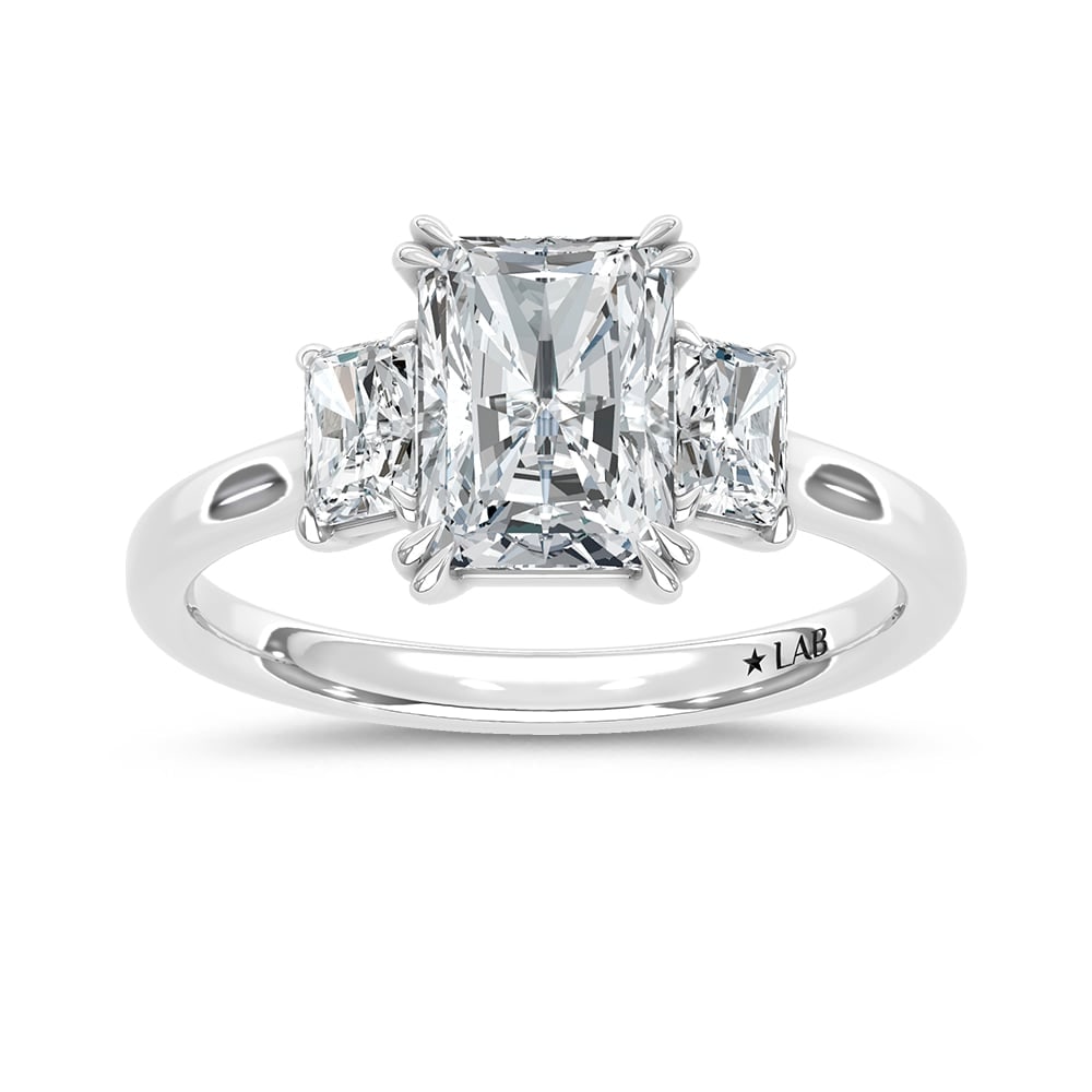 14K White Gold Lab Grown Diamond 2 Ct.Tw. Elongated Radiant Cut Three Stone Engagement Ring: 14K White Gold Lab Grown Diamond 2 Ct.Tw. Elongated Radiant Cut Three Stone Engagement Ring This stunning three-stone ring features a sparkling 1 1/2 CT Elongated Radiant Center diamond with two shimm