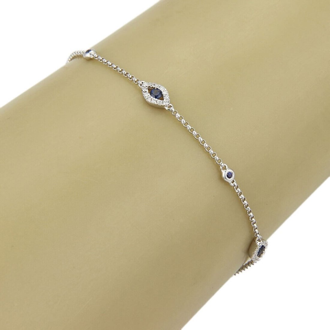18k White Gold Link Bracelet with Evil Eye Sapphire and Diamond Accents: 18k White Gold Link Bracelet with Evil Eye Sapphire and Diamond Accents This Evil Eye bracelet features a vibrant blue sapphire center surrounded by sparkling diamonds, all set in 18k white gold. The