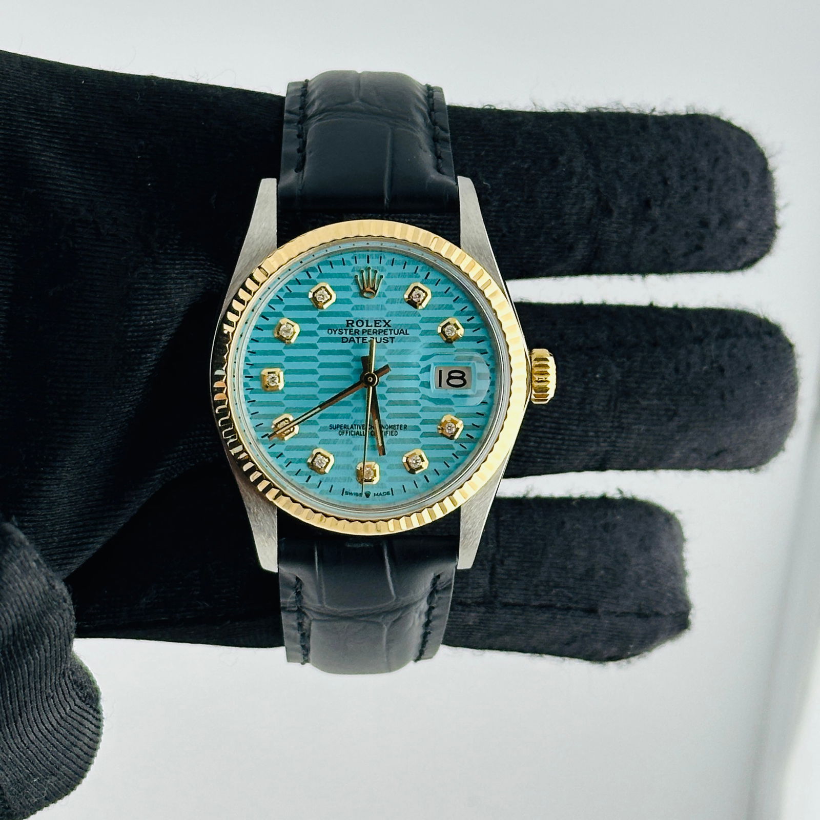 Datejust Ref 16013 Teal Fluted Dial Watch with Aftermarket Leather Strap: Datejust Ref 16013 Teal Fluted Dial Watch with Aftermarket Leather Strap This Rolex Datejust watch features a teal fluted motif dial and a fluted bezel. It is designed for men and comes equipped with