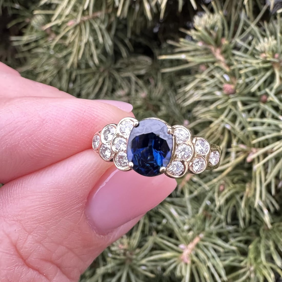 Oval Sapphire and Diamond Ring in 14k Yellow Gold with Step Accents: Oval Sapphire and Diamond Ring in 14k Yellow Gold with Step Accents This cocktail ring features a deep royal blue, oval brilliant cut natural sapphire set in a 14k yellow gold band. Accenting the sapp