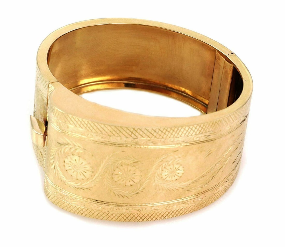 Wide Hinged Bracelet in 14k Yellow Gold Polished Bangle Design: Wide Hinged Bracelet in 14k Yellow Gold Polished Bangle Design This is a fancy wide hinged bangle bracelet crafted from 14k yellow gold. The bracelet features a polished finish and a hinged design for