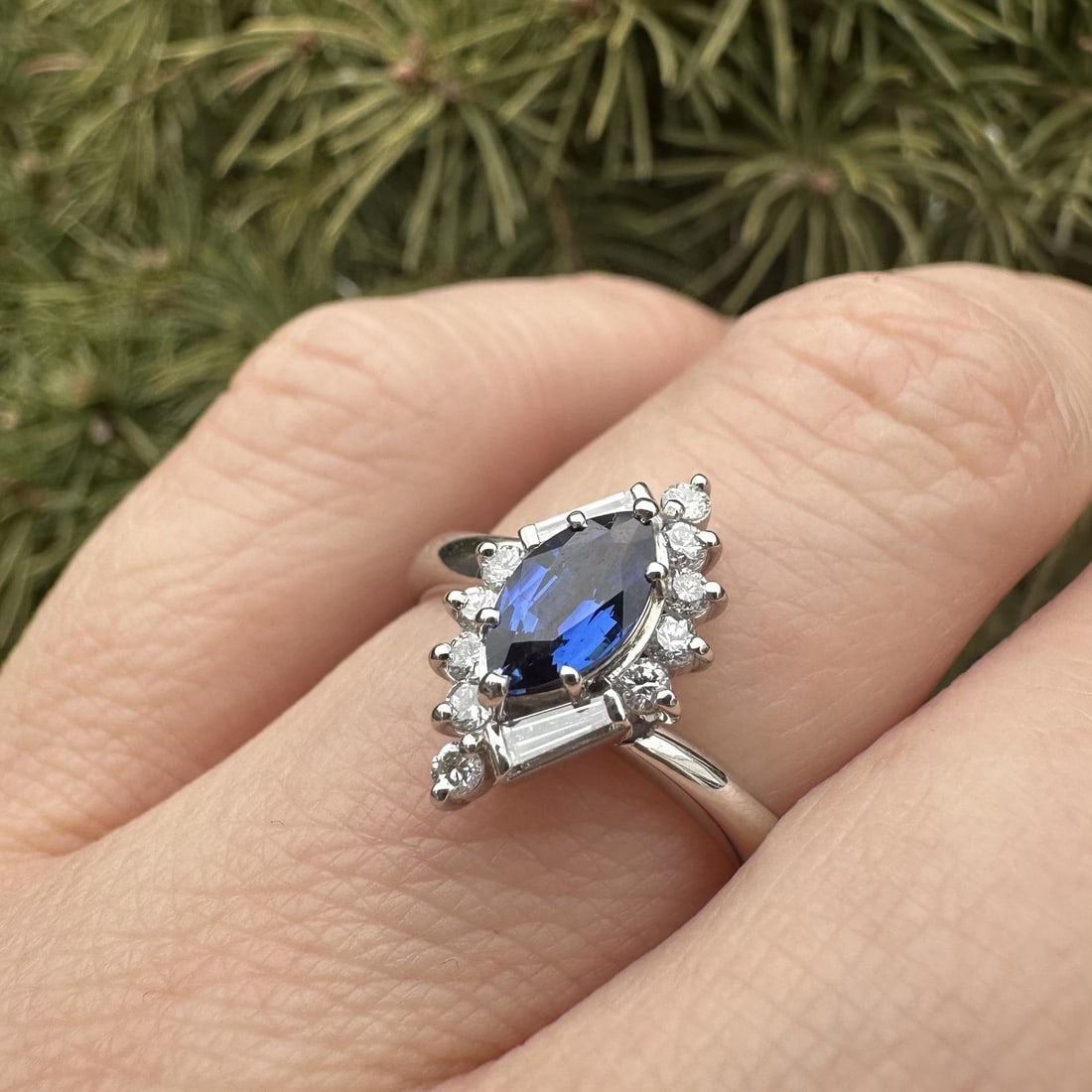 Platinum Cocktail Ring with Marquise Blue Sapphire and Diamond Accents: Platinum Cocktail Ring with Marquise Blue Sapphire and Diamond Accents This elegant cocktail ring features a natural marquise-cut sapphire with a brilliant blue color, set in solid .900 platinum. The