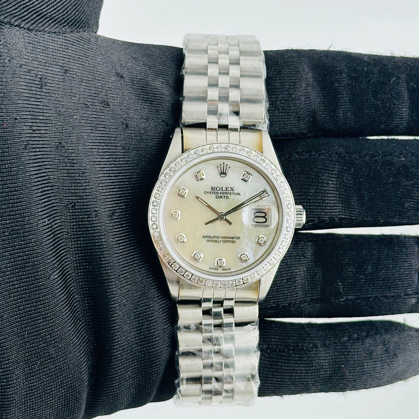 Aftermarket Jubilee Band Rolex 6694 Oyster Perpetual Date White MOP Dial: Aftermarket Jubilee Band Rolex 6694 Oyster Perpetual Date White MOP Dial This Rolex Oyster Perpetual Date features an aftermarket white mother-of-pearl dial set within a reference 6694 case. The bezel