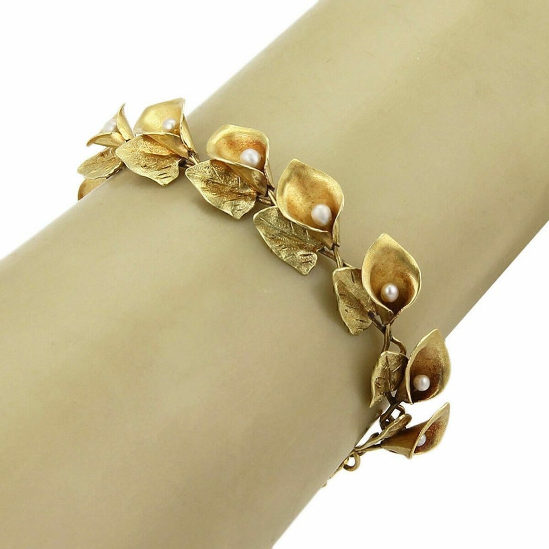 18k Yellow Gold Link Bracelet with Pearl and Calla Lily Motif Art Nouveau: 18k Yellow Gold Link Bracelet with Pearl and Calla Lily Motif Art Nouveau This vintage Art Nouveau bracelet is crafted from 18k yellow gold and features a delicate calla lily and pearl motif. The link