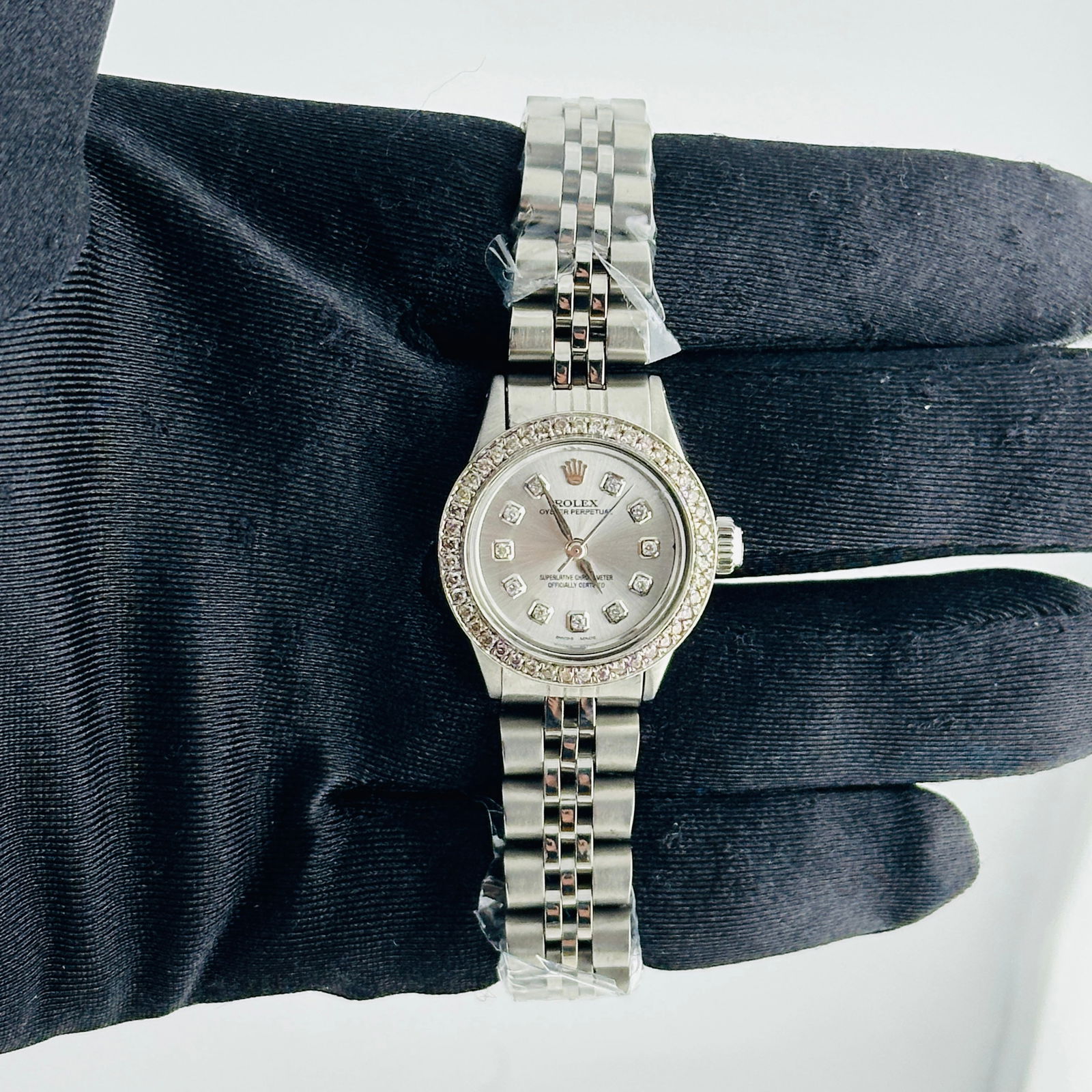 Ladies Aftermarket Silver Diamond Dial Oyster Perpetual Ref 6411 Jubilee Watch: Ladies Aftermarket Silver Diamond Dial Oyster Perpetual Ref 6411 Jubilee Watch This ladies Rolex Oyster Perpetual features a silver diamond aftermarket dial, a pave diamond bezel, and an aftermarket J
