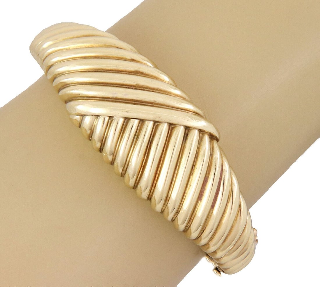 Asymmetrical 14k Yellow Gold Bangle With Deep Groove By La Triomphe: Asymmetrical 14k Yellow Gold Bangle With Deep Groove By La Triomphe This La Triomphe bangle bracelet is crafted from solid 14k yellow gold and features an asymmetrical design with deep groove detailin