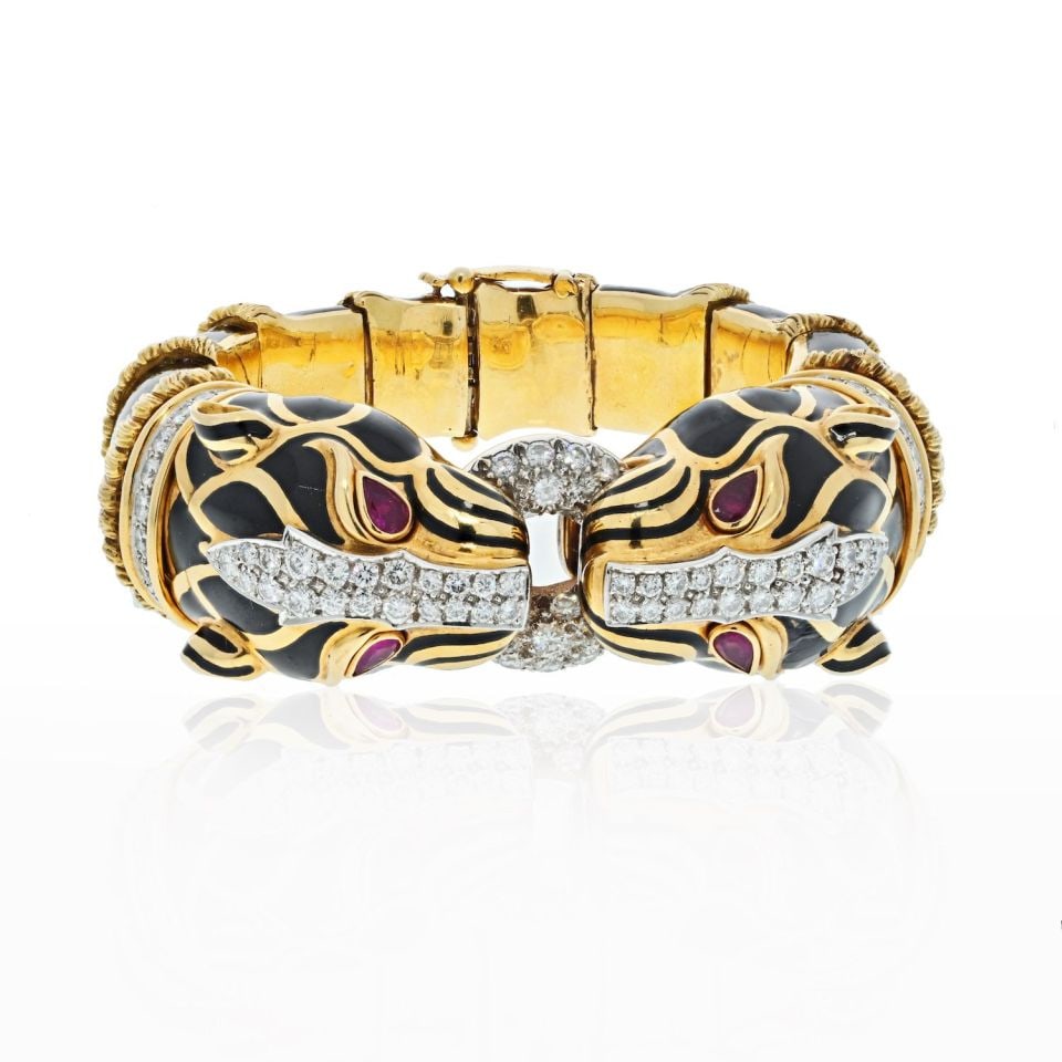 David Webb Platinum 18K Gold Double Lion Enamel Bracelet: David Webb Platinum 18K Gold Double Lion Enamel Bracelet This exquisite David Webb bracelet showcases a striking design featuring two opposing double head lions adorned in black enamel. Crafted from a