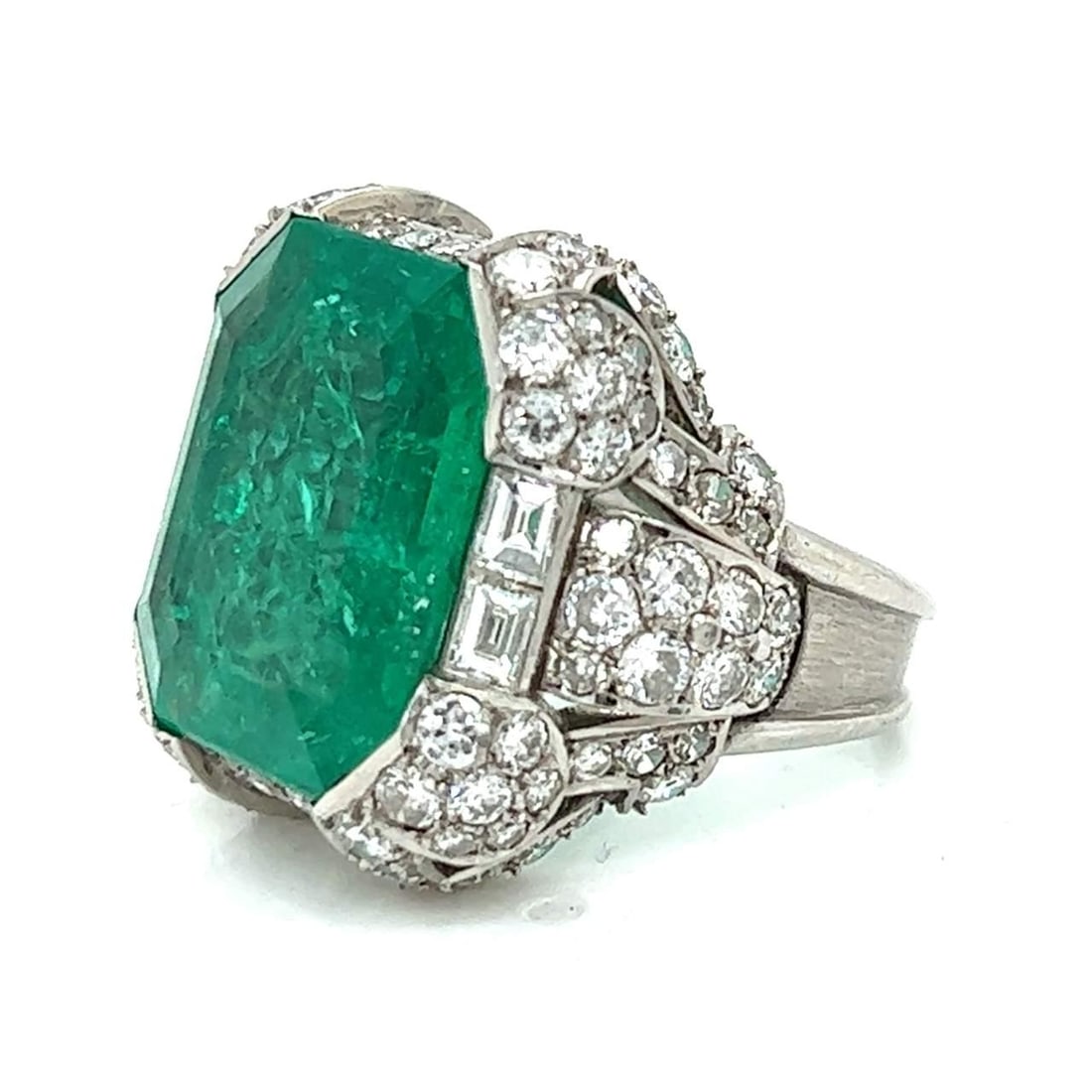 Art Deco Platinum Ring with 10.50 Ct Colombian Emerald and Diamonds: Art Deco Platinum Ring with 10.50 Ct Colombian Emerald and Diamonds This exquisite Art Deco ring features a stunning Colombian emerald weighing approximately 10.50 Ct, beautifully complemented by 104