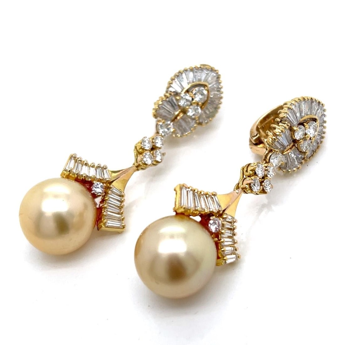 South Sea Pearl and Diamond Drop Earrings in 18K Yellow Gold: South Sea Pearl and Diamond Drop Earrings in 18K Yellow Gold These elegant earrings are crafted from 18K yellow gold and feature two South Sea pearls measuring between 12.7 mm and 12.6 mm. The design