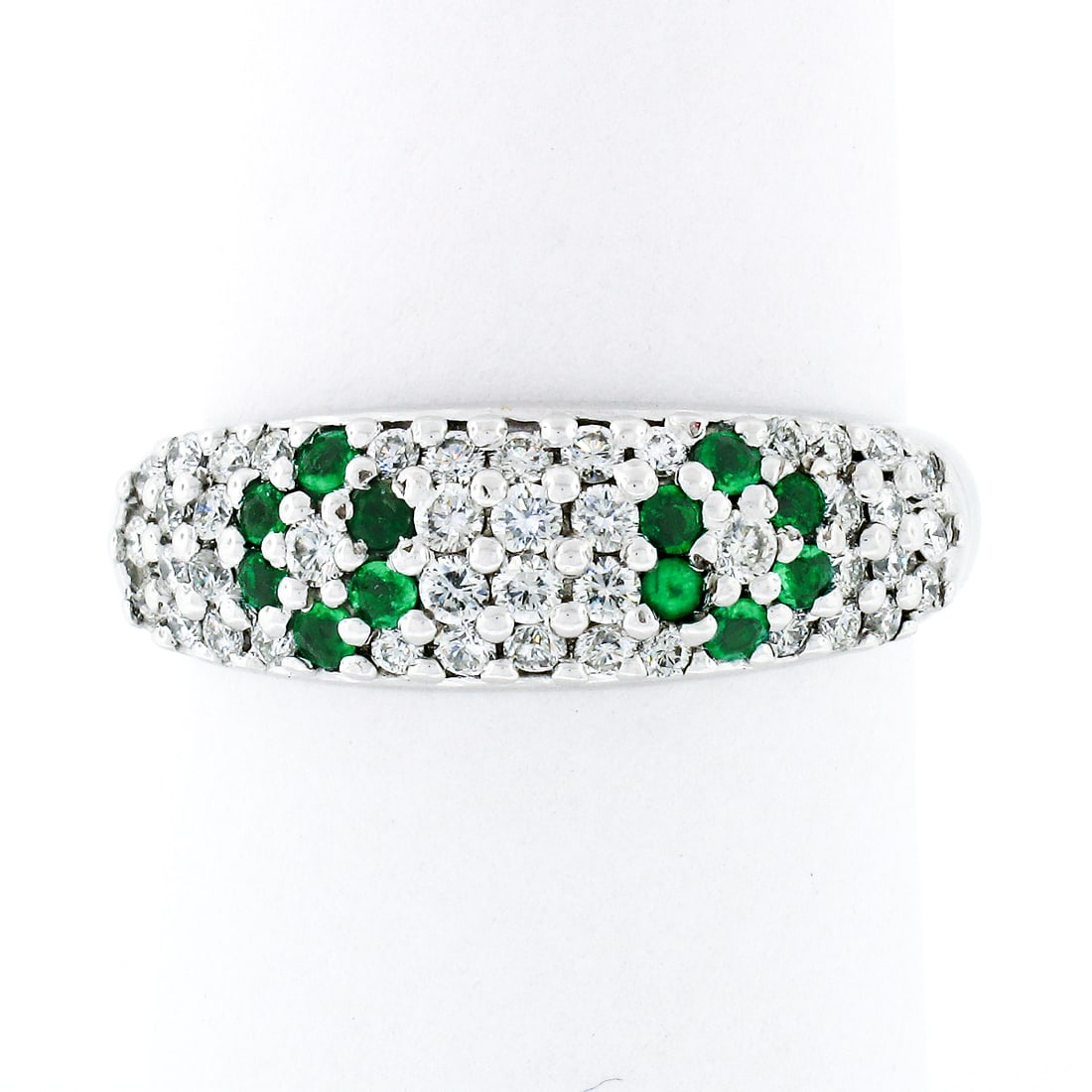 Elegant 18K White Gold 0.68ctw Emerald Diamond Flower Cluster Band Ring: Elegant 18K White Gold 0.68ctw Emerald Diamond Flower Cluster Band Ring This exquisite 18K White Gold band ring showcases a stunning dome design adorned with a vibrant cluster of natural emeralds and