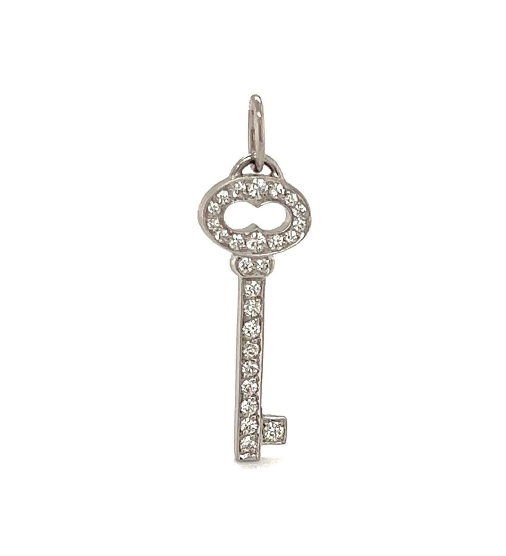 Mini Oval Key Pendant in Platinum with Diamonds by Tiffany & Co.: Mini Oval Key Pendant in Platinum with Diamonds by Tiffany & Co. This Tiffany & Co. mini oval key charm pendant features a delicate key design crafted in platinum and adorned with 0.12 carats of diamo