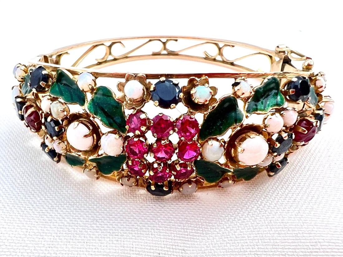 1940's 18K Rose Gold Cuff Bracelet with Opal Ruby Sapphire: 1940's 18K Rose Gold Cuff Bracelet with Opal Ruby Sapphire This exquisite 1940's bracelet is crafted from 18K rose gold and features a stunning combination of sapphire, ruby, and opal stones, set agai