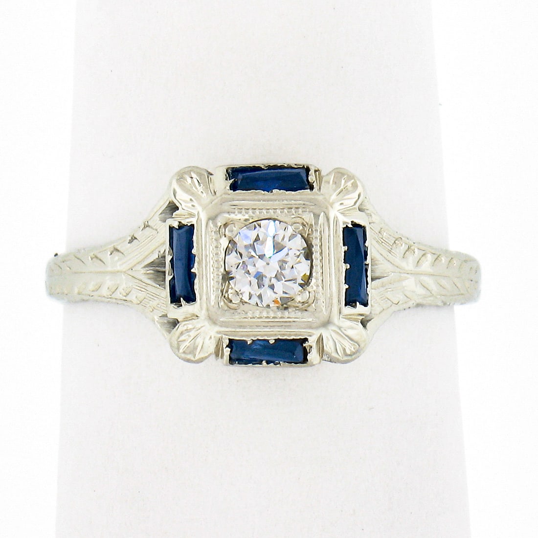 Antique Art Deco 18K White Gold 0.15ct Diamond Sapphire Engraved Ring: Antique Art Deco 18K White Gold 0.15ct Diamond Sapphire Engraved Ring This exquisite Antique Art Deco ring, crafted in solid 18K white gold, showcases a stunning Old European cut diamond at its center