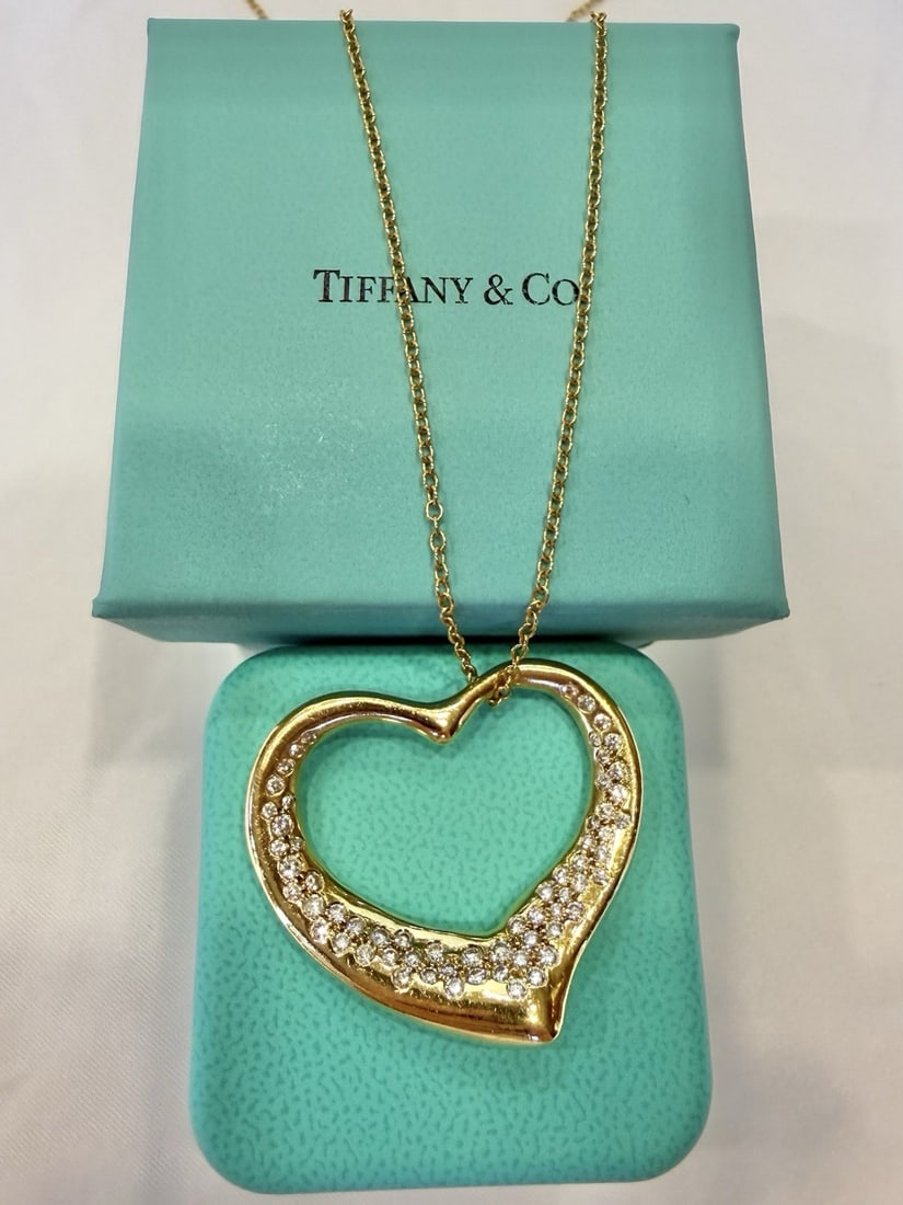 18K Yellow Gold Diamond Heart Pendant Necklace by Tiffany with Original Boxes: 18K Yellow Gold Diamond Heart Pendant Necklace by Tiffany with Original Boxes This Tiffany & Co. 18K yellow gold necklace features a heart-shaped pendant adorned with a sparkling diamond. The chain ha