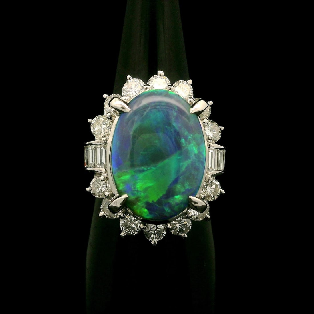 Vintage GIA Certified 6.72ctw Black Opal Diamond Halo Platinum Ring: Vintage GIA Certified 6.72ctw Black Opal Diamond Halo Platinum Ring This exquisite vintage cocktail ring showcases a stunning 6.72ctw black opal surrounded by a brilliant diamond halo. The main stone