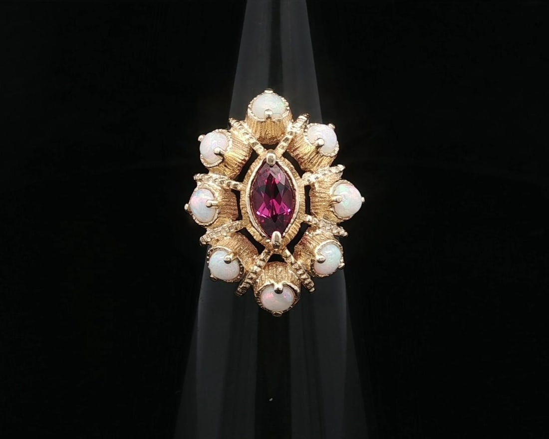 Vintage 14k Yellow Gold Opal and Rhodolite Garnet Cocktail Ring: Vintage 14k Yellow Gold Opal and Rhodolite Garnet Cocktail Ring This vintage cocktail ring showcases a stunning arrangement of natural gemstones in a textured marquise shape. The centerpiece features