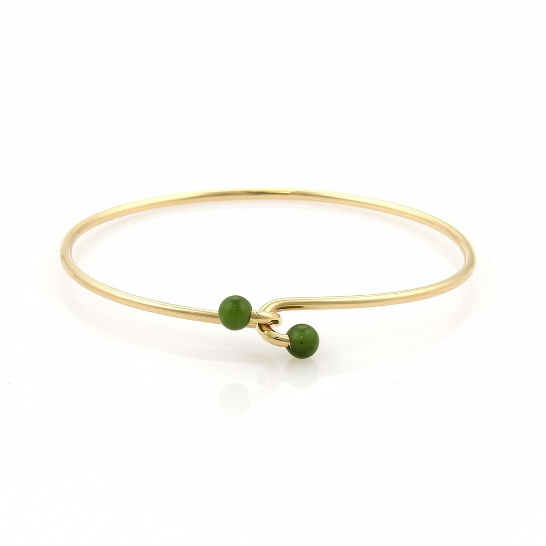 Jade Accent 14k Yellow Gold Wire Hook Bangle Bracelet by Tiffany & Co.: Jade Accent 14k Yellow Gold Wire Hook Bangle Bracelet by Tiffany & Co. This vintage Tiffany & Co. bangle bracelet features a sleek wire hook design crafted in 14k yellow gold and is accented with a vi