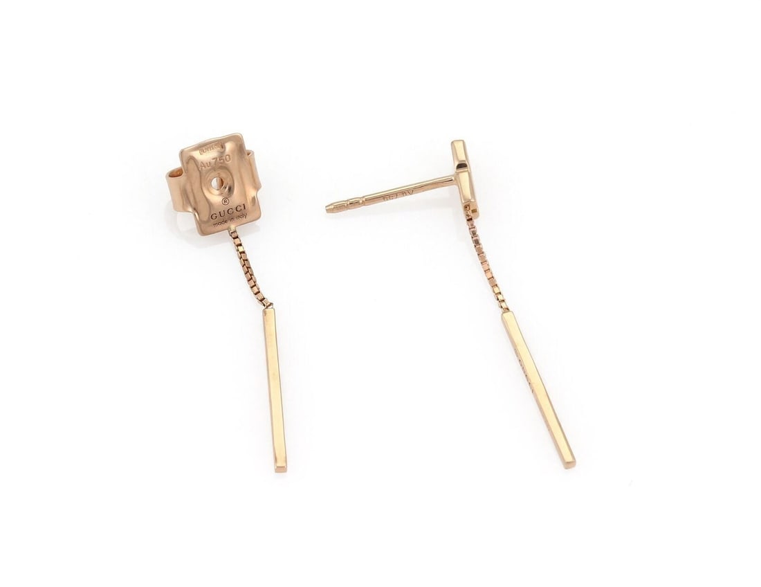 18k Pink Gold Double Bar Dangle Earrings by Gucci: 18k Pink Gold Double Bar Dangle Earrings by Gucci These Gucci dangle earrings are crafted from 18k pink gold and feature double long bar drops with the iconic Gucci logo etched on each bar. The earrin