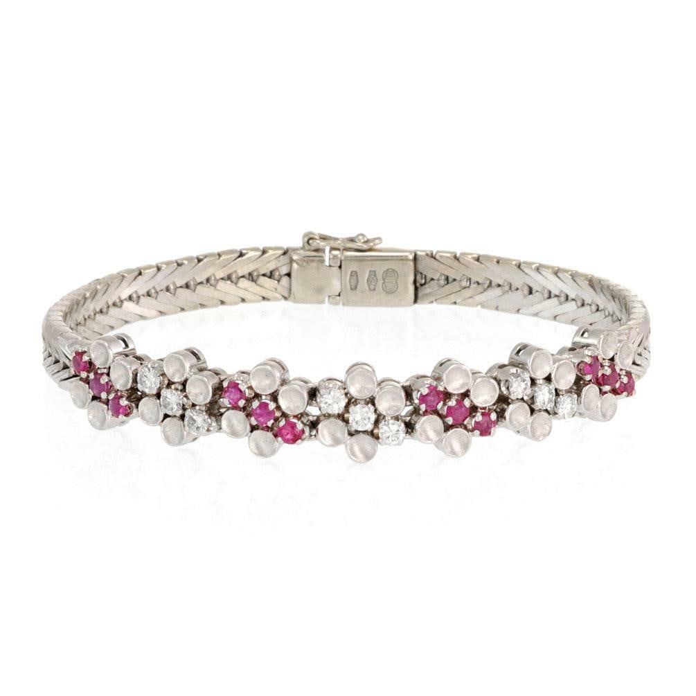 Elegant 18k White Gold Floral Bracelet with Rubies and Diamonds: Elegant 18k White Gold Floral Bracelet with Rubies and Diamonds This exquisite floral bracelet is meticulously crafted from 18k white gold and features a stunning centerpiece adorned with eight flower