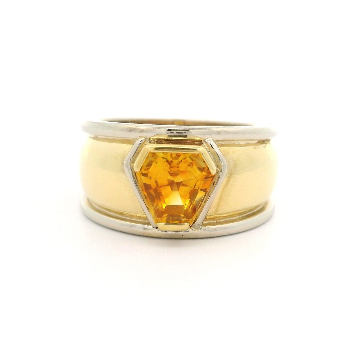 18k Two Tone Gold GIA Certified Shield Step Cut Yellow Sapphire Cigar Band Ring: 18k Two Tone Gold GIA Certified Shield Step Cut Yellow Sapphire Cigar Band Ring This stunning 18k Two Tone Gold Ring features a captivating shield step cut yellow sapphire, expertly set in solid 18k y