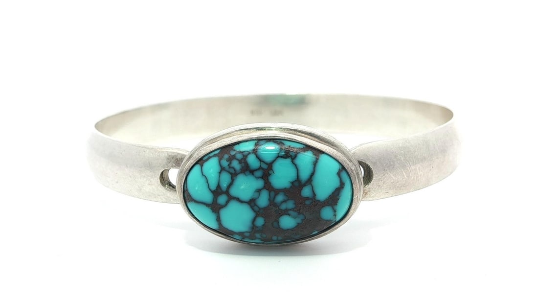 Vintage Sterling Silver Turquoise Cabochon Bangle Bracelet: Vintage Sterling Silver Turquoise Cabochon Bangle Bracelet This exquisite vintage bangle bracelet features a stunning natural turquoise cabochon, showcasing a beautiful blue color with a distinctive m