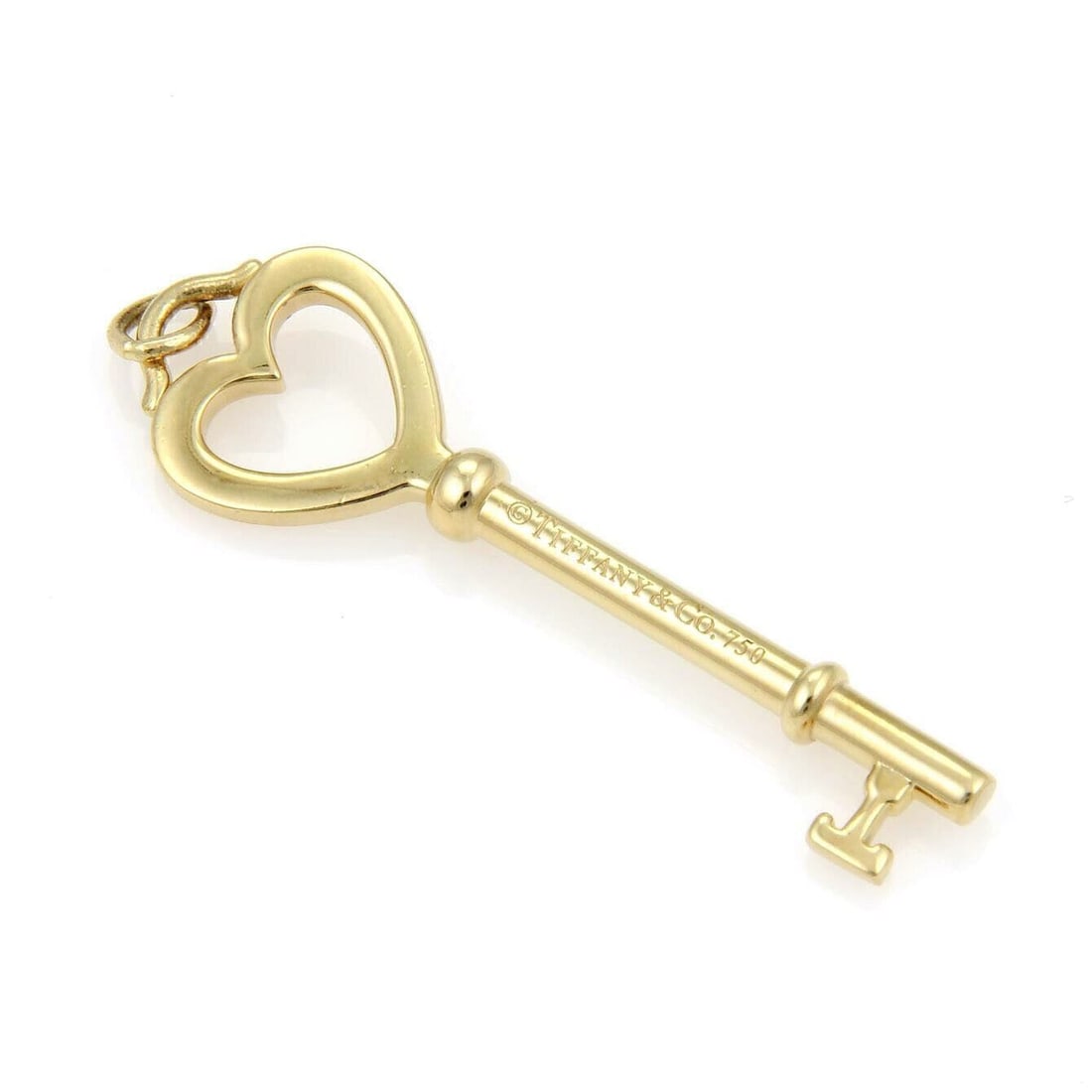 18k Yellow Gold Heart Key Pendant Charm by Tiffany & Co.: 18k Yellow Gold Heart Key Pendant Charm by Tiffany & Co. This Tiffany & Co. pendant features a classic heart-shaped key charm crafted in 18k yellow gold. Signed by Tiffany & Co., the piece is an elega