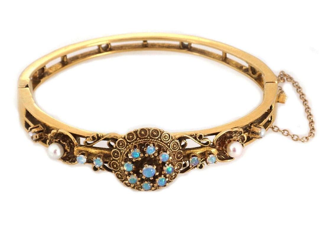 Vintage 14k Gold Bangle With Opal Cabochons and Seed Pearls Floral Motif: Vintage 14k Gold Bangle With Opal Cabochons and Seed Pearls Floral Motif This vintage bangle bracelet is crafted from 14k yellow gold and features a floral center design adorned with small round caboc