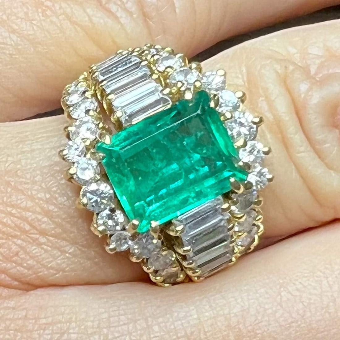 18K Yellow Gold Emerald 4.00 Ct and 42 Diamond Ring: 18K Yellow Gold Emerald 4.00 Ct and 42 Diamond Ring This stunning 18K yellow gold ring features a captivating Colombian emerald at its center, weighing approximately 4.00 ct. The ring is adorned with