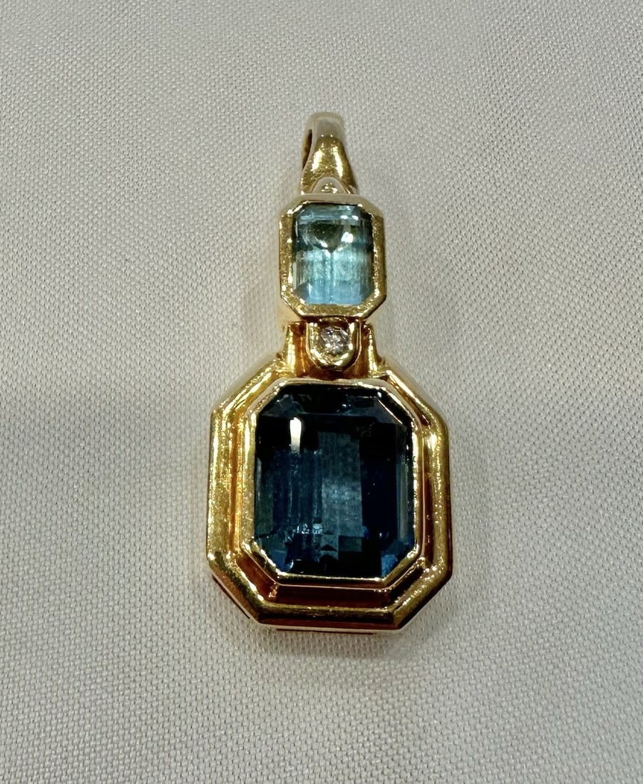 Stunning 14K Yellow Gold Blue Topaz Diamond Pendant: Stunning 14K Yellow Gold Blue Topaz Diamond Pendant This stunning pendant features a captivating combination of blue topaz and diamond set in 14k yellow gold. The piece showcases exquisite craftsmansh